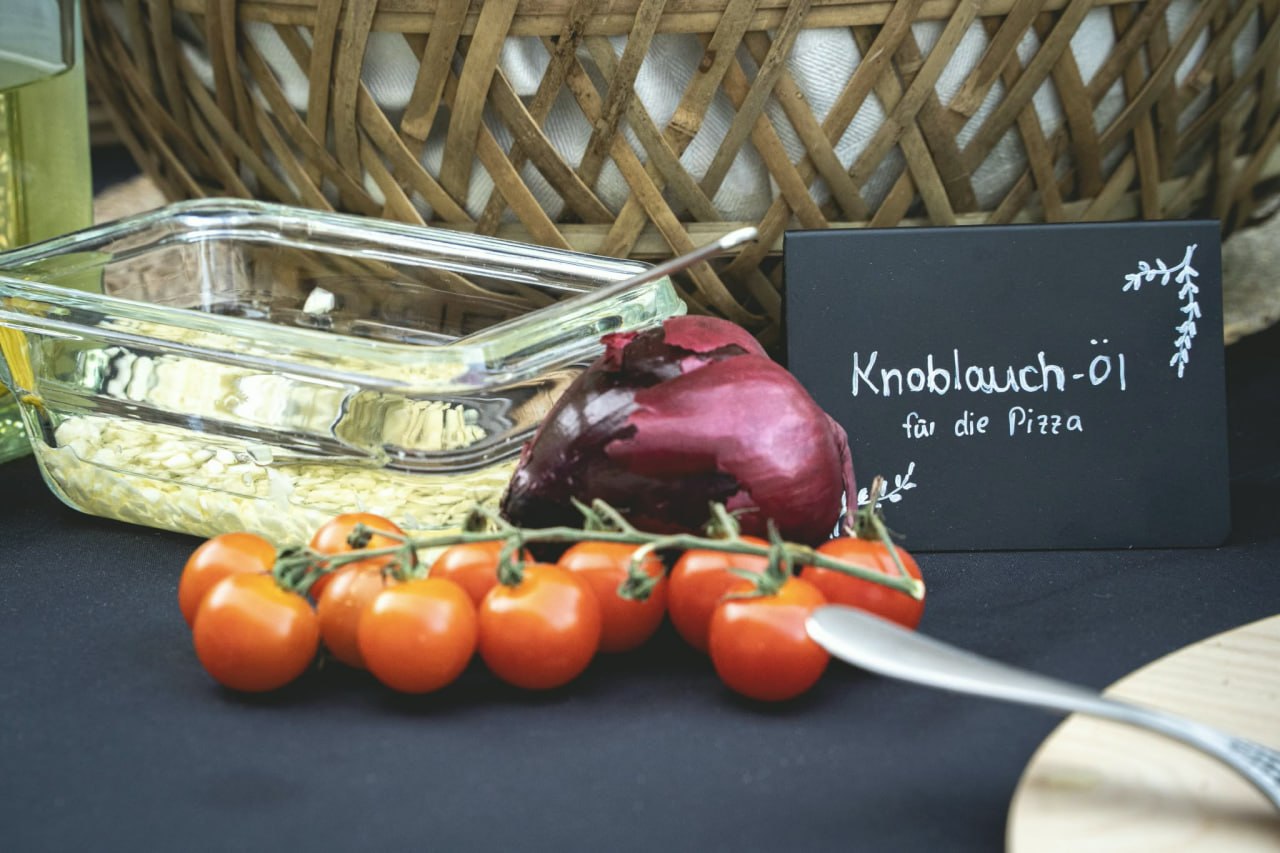 Knoblauchöl, Cocktailtomaten und rote Zwiebeln mit Kreideschild
